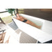 Man stretched out with legs extended in the AMBOHR All-in Ice Bath Machine tub on a screened porch