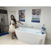 Woman pointing at the empty basin of the AMBOHR All-in Ice Bath Systems tub inside a retail showroom