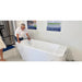 Showroom staff member leaning over the empty AMBOHR All-in Cold Plunge Spa while holding the filter hose