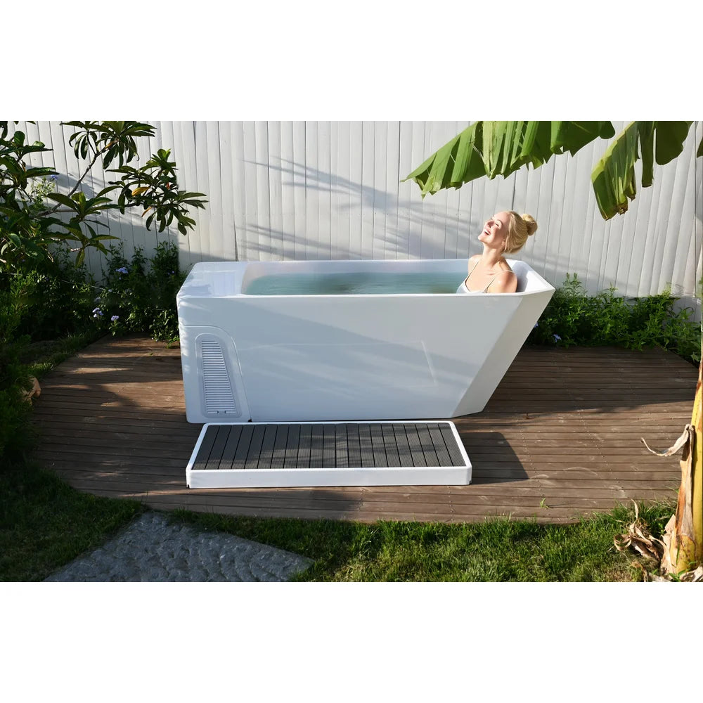 Woman soaking in the AMBOHR All-in Cold Plunge Spa on a garden deck with the slatted step mat alongside