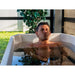 Man relaxing shoulder-deep in an outdoor plunge tub cooled by the AMBOHR Mini Chiller Ice Bath Chiller