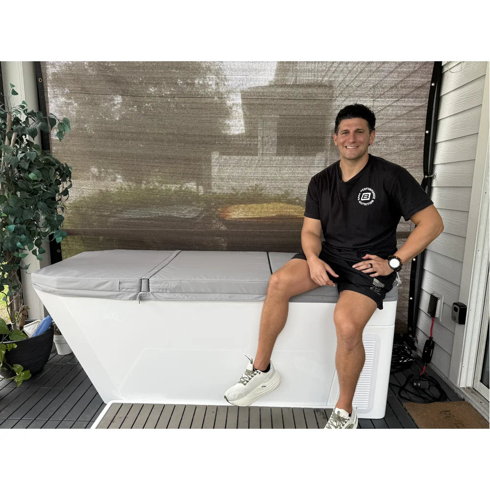 Man sitting on a covered patio plunge tub chilled by the AMBOHR Ultra Chiller Water Chiller unit at home