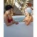Two friends in beanies sharing an outdoor ice bath cooled by the AMBOHR Ultra Chiller Cold Plunge setup