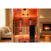 Close lifestyle crop of the Blisspod Vantaa RED Red Light Therapy Sauna interior glowing in a living room
