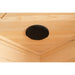 Black oval ceiling speaker recessed into the hemlock planks of the Blisspod Vienna Sauna audio system