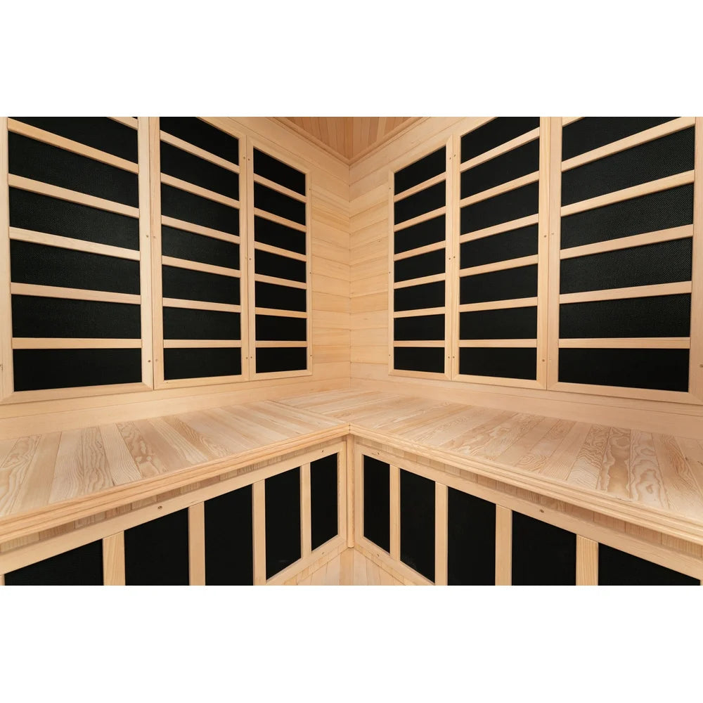 Interior rear walls of the Blisspod Vienna Hemlock Sauna lined with tall black carbon heater panels above the bench