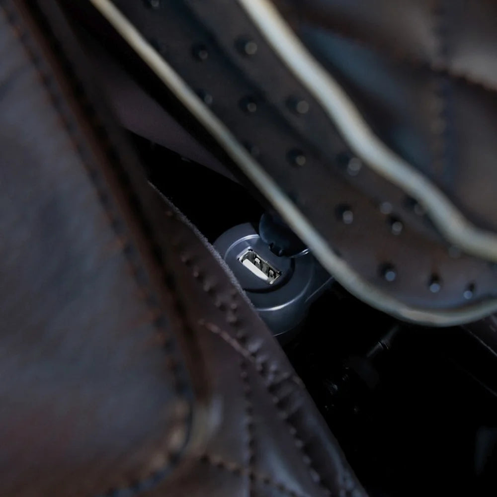 Close-up of the USB charging port tucked beside the brown quilted seat of the Infinity Palisade Pro 4D Massage Recliner