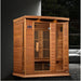 Red cedar cabin of the Maxxus Montilemar FAR IR Sauna set in a modern living room beside a window and sofa
