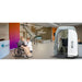 Nurse assisting a seated patient beside the open Oxyrevo Heal 40 Wheelchair Hyperbaric Chamber in a clinic lobby