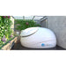 Open-lid Dreampod Sport on a covered outdoor deck framed by ivy-covered walls and flowering plants