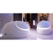 Pair of Dreampod Sport Float Tank units with glowing rim lighting arranged in a dark stone-walled spa room