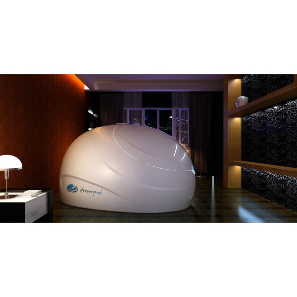 Side profile of a closed Dreampod Sport Isolation Tank staged in a dark bedroom with a city window view