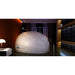 Side profile of a closed Dreampod Sport Isolation Tank staged in a dark bedroom with a city window view