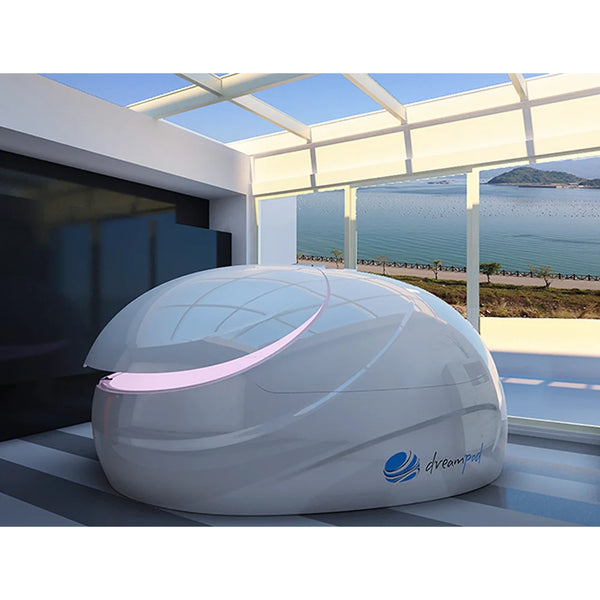 Angled view of a white Dreampod V2 Price model with pink door seam lighting in a glass sunroom by the water