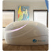 Closed white Dreampod V2 Float Pod seen from the front with pink door seam lighting in a sunlit room