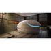 Champagne toned pod with tilted lid and blue crescent light next to a walk-in shower, the Dreampod Vmax Sensory Deprivation Tank