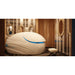 White pod with raised door and deep blue interior light in a wood panelled salon, the Dreampod Vmax Float Tank on display