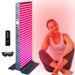 Illuminated EXESAS 1620W Full Body Red Light Therapy Device on its stand with remote control and safety glasses