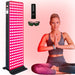 Illuminated EXESAS 200 LED Full Body Red Light Therapy Device on its stand with remote control and safety goggles