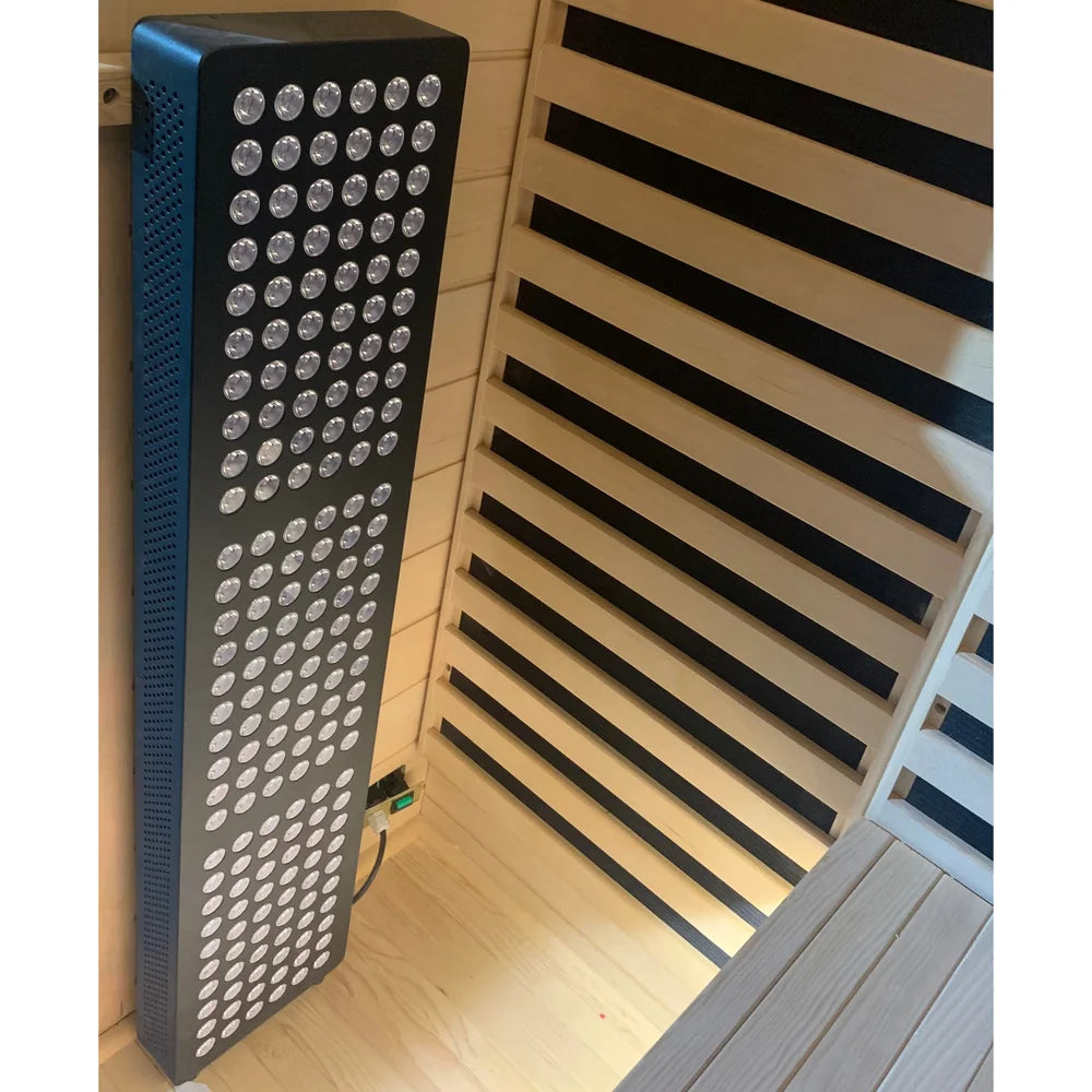 Tall LED red light therapy panel standing in the corner of the Blisspod Bergen Sauna Pod beside the bench