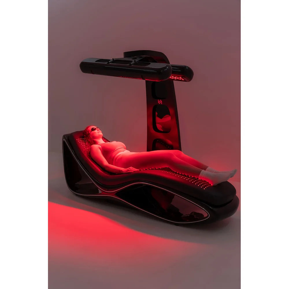 Complete side view of the Vacu Activ Red Couch 360 with a goggled client lying on the glowing LED mattress