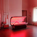 Person lying inside the open Galaxy Zero Capsule LED Light Therapy Bed during a full red light session in a treatment room