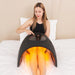 Woman adjusting the top touch panel of the Galaxy Zero Trinty Red Light Therapy Device over her legs in bed
