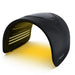 Angled studio shot of the Galaxy Zero Trinty Red Light Therapy Device glowing in yellow light mode on white