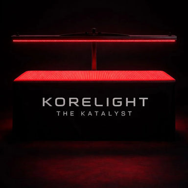 Red LED mat and overhead bar glowing in a dark studio on the KoreLight KoreStation Red Light Therapy System