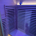 Interior of the Blisspod Helsinki Sauna Pod under purple light with backrest, heater slats and ionizer