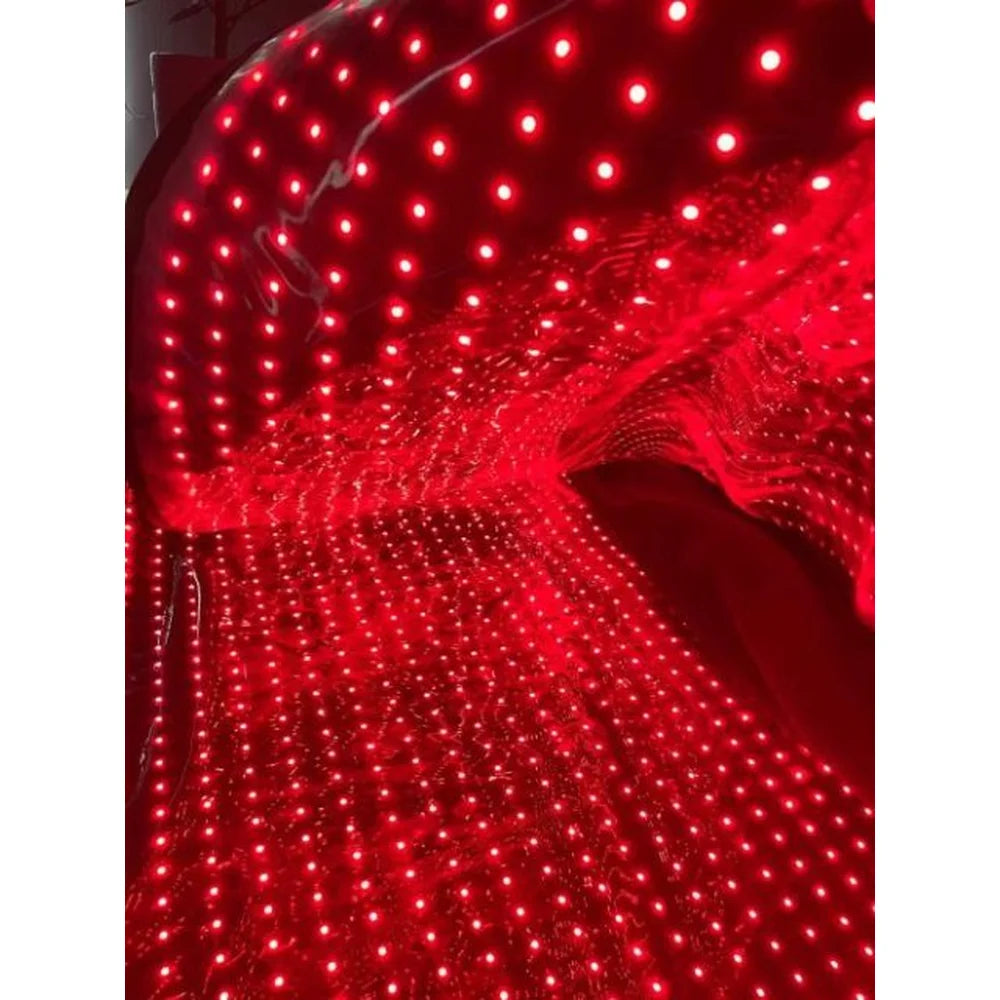 Rows of red LEDs glowing inside the Kore KoreKapsule Full Body Red Light Therapy Pad under a clear protective film
