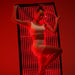 Woman in white activewear strikes a pose before an upright lit Kore KoreKapsule Full Body Red Light Therapy Device panel