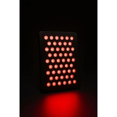 Black rectangular panel with glowing red LED grid at a slight angle, the KoreLight KoreNRG Light Therapy on a dark backdrop