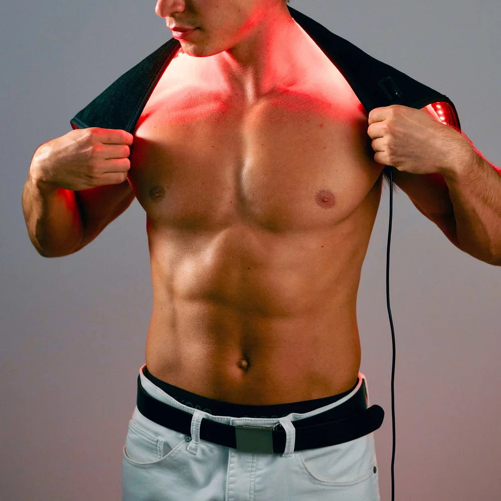 Man pulling the Lumara Pad across his shoulders so red light covers his neck and upper chest