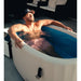 Sunlit soak with arm over the rim of the Revive Inflatable Cold Plunge Tub filled with cold water