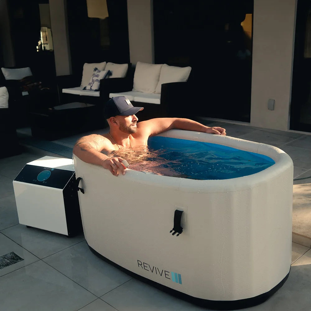 Patio soak in the Revive Inflatable Cold Plunge Tub with the chiller unit running alongside at dusk