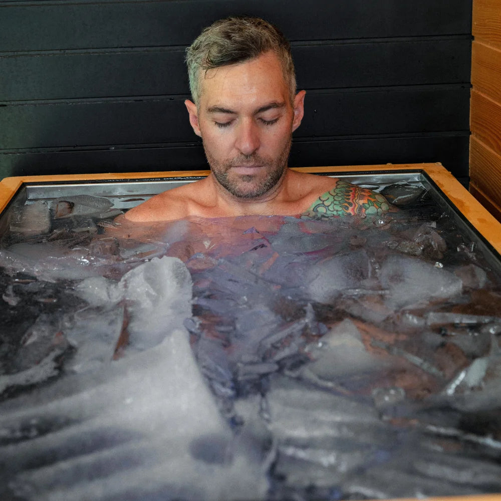 Man sitting chest-deep in floating ice inside the Revive Plunge Luxury Plunge Cold Plunge Bath