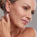 Mature woman touching her neck with smooth firm skin after sessions with the Galaxy Zero Atlas Body Wellness Device