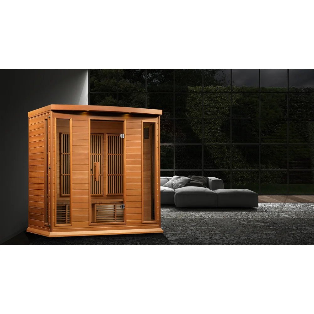 Maxxus Chaumont Infrared Sauna set up beside a grey sofa in a modern room with floor-to-ceiling windows