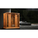 Maxxus Chaumont Infrared Sauna set up beside a grey sofa in a modern room with floor-to-ceiling windows