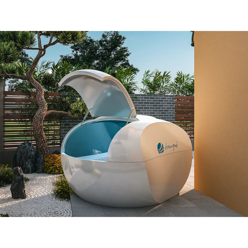 Egg-shaped Dreampod Home Float Plus Flotation Tank with lid open beside a zen rock garden