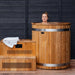 Ora Ice Bath cedar cold plunge and matching steps set up against a dark timber wall