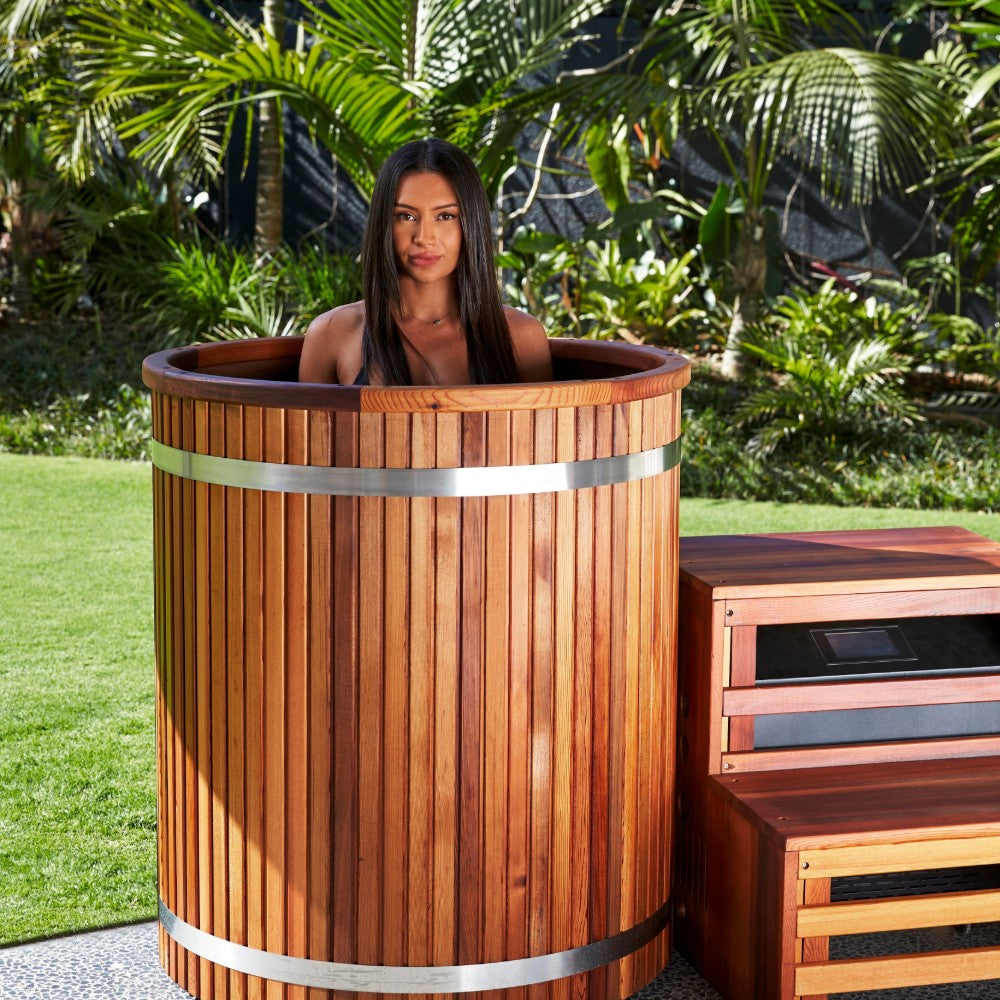 Ora Ice Bath red cedar barrel cold plunge tub set up outdoors in a backyard garden