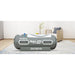 Grey OxyRevo Apex36 Hyperbaric Chamber set up on a rug in a bright living room beside an armchair