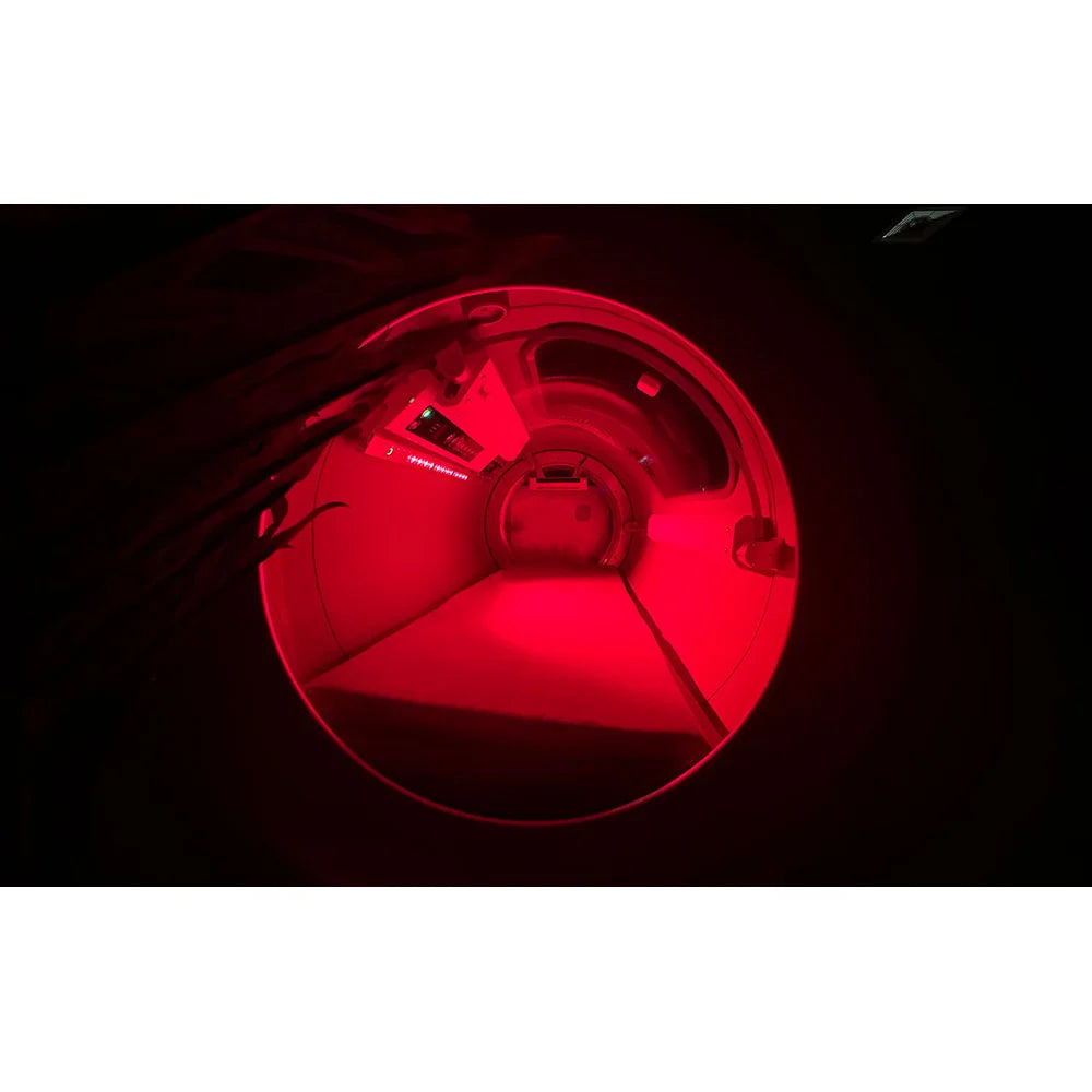 Interior of the OxyRevo Quest30 Hard Hyperbaric Chamber glowing red with the optional therapy panel switched on