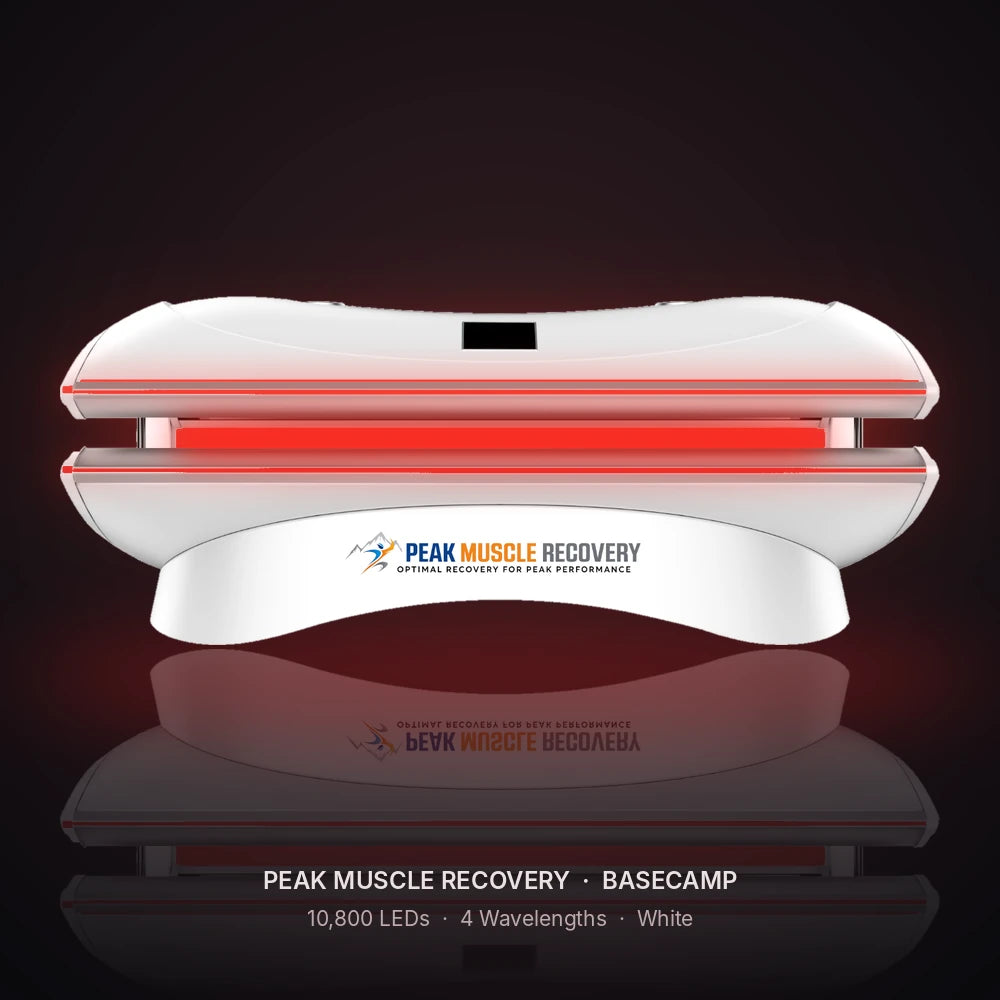 White Peak Muscle Recovery Basecamp Red Light Therapy Bed with red LEDs glowing in a dark studio