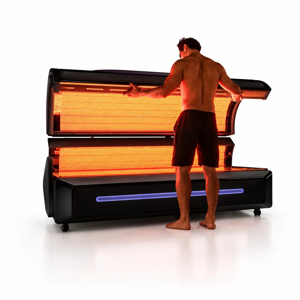 Man lifting the illuminated upper canopy of the RevitalCore Apex M6 Red Light Bed with orange LED panels lit