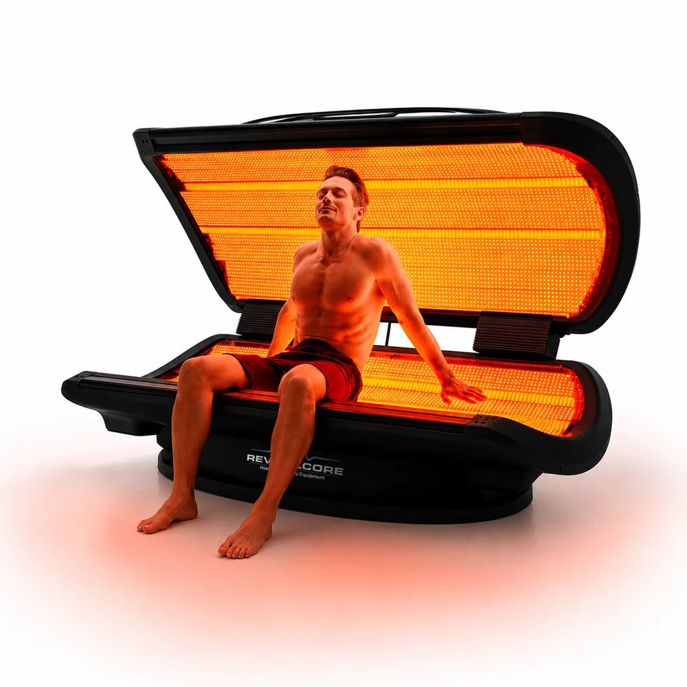 Seated user relaxing on the glowing lower LED panel of the Elevate by RevitalCore Elevate M7 Light Bed