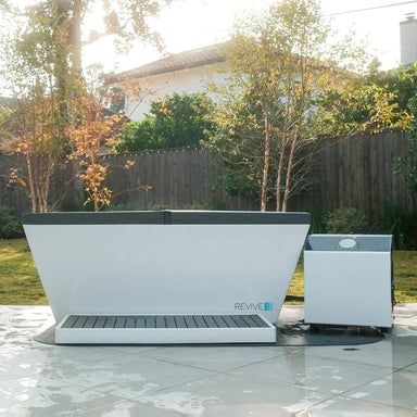Covered Revive Plunge Acrylic Plunge Tub with step and chiller set up on a backyard tile patio