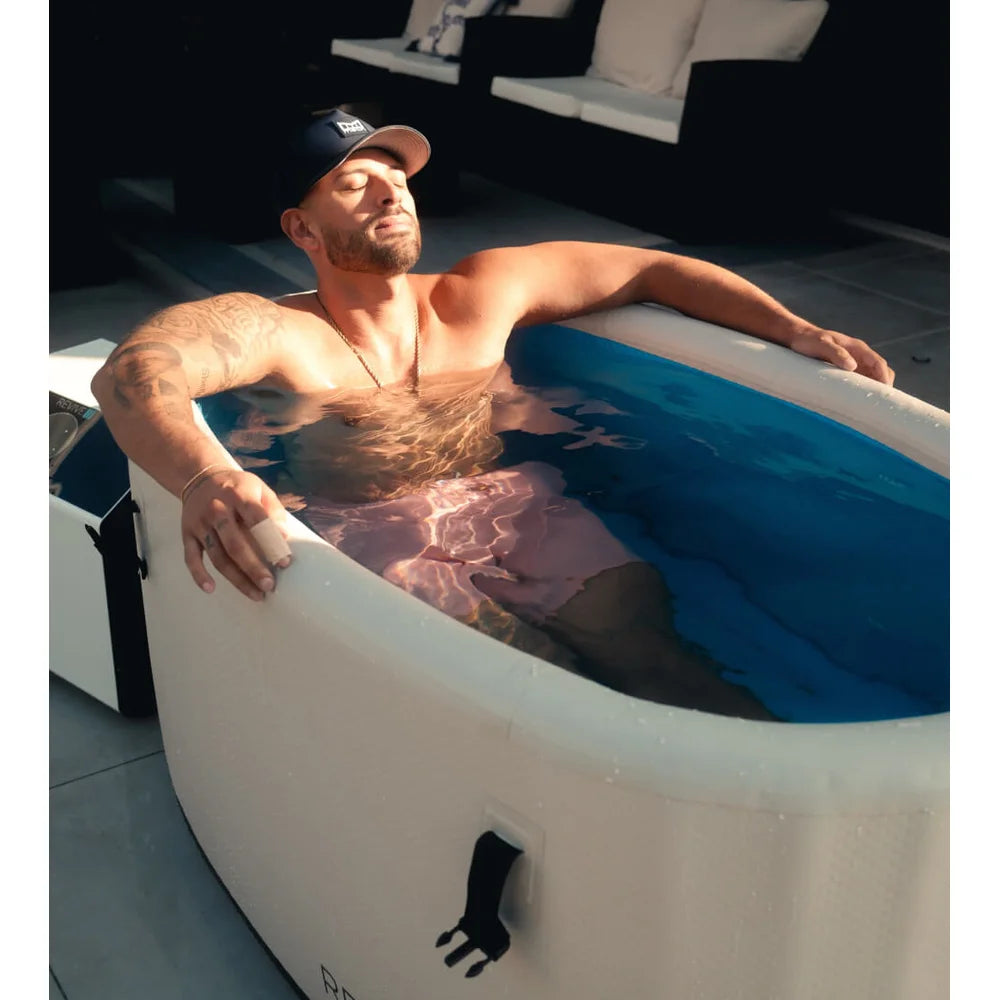 Man relaxing eyes closed in cold water on a patio during a session with the Revive Plunge Inflatable Barrel Plunge Cold Plunge
